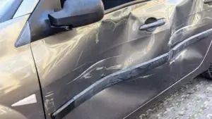 A car with a huge indent on the driver door.