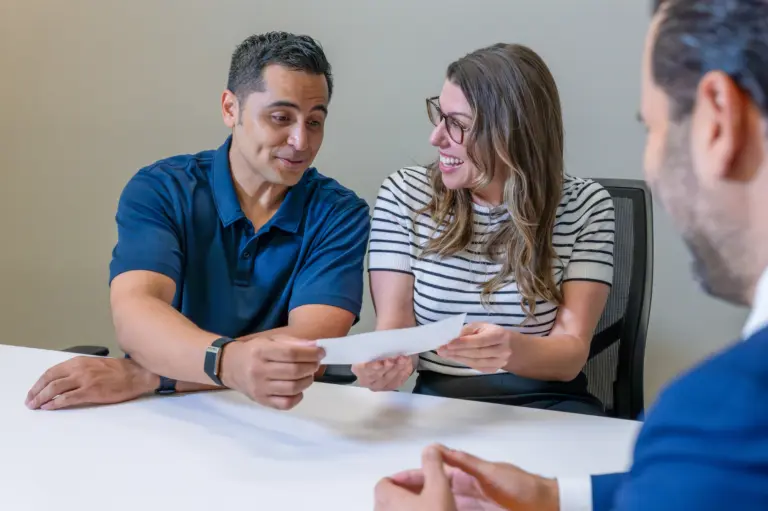 A happy couple receiving a check for their claim.