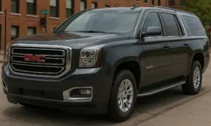 A navy GMC Yukon on a street.