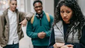 Two guys hitting on a woman who is clearly not interested. 