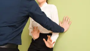 A man pinning a woman against the wall. 