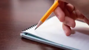 A person taking notes on a notepad. 